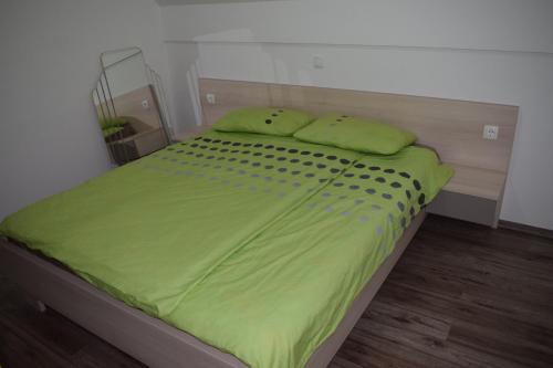 卡特兹奥布萨维Borovnica Čatež的一张带绿床单和枕头的床