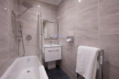 海华德希思桦树酒店的带浴缸、淋浴和盥洗盆的浴室