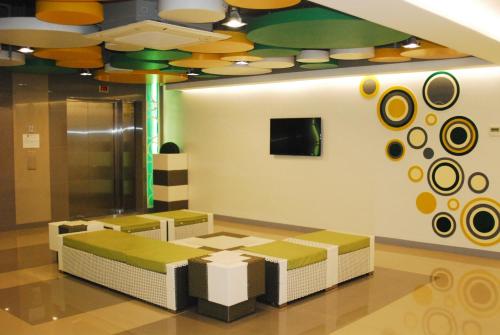 马尼拉Go Hotels Ortigas Center的一间设有两张长椅和天花板的等候室