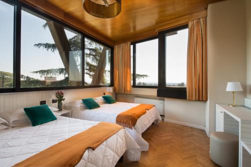 蒙特卡蒂尼泰尔梅全景大酒店的带大窗户的客房内的两张床