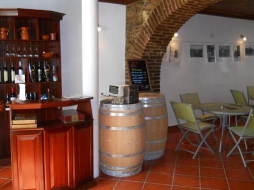 费雷拉杜阿连特茹贵族庄园度假酒店的一间设有两个酒桶和桌椅的房间