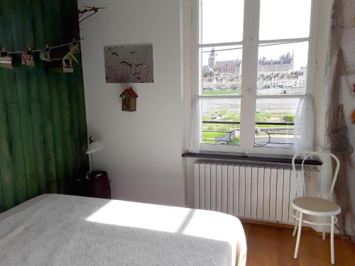 日安Le Repos du Marinier的卧室配有白色的床和窗户。
