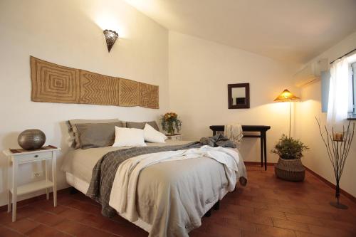 博尔焦韦雷齐Blu Oltremare的一间卧室配有一张床和一张带台灯的桌子