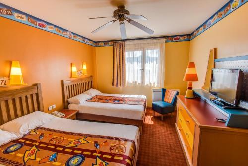 考普瓦利Disney Hotel Santa Fe的一间卧室配有两张床和一台平面电视