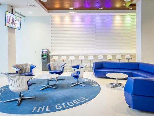 多伦多多伦多市区会议中心公寓的一间配备有蓝色沙发和椅子的等候室