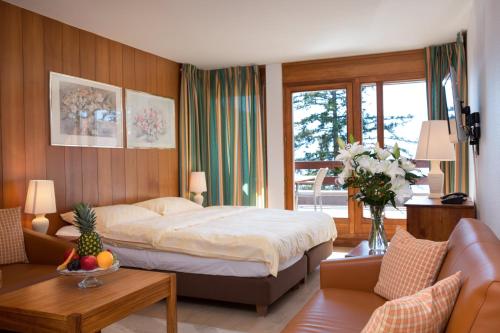 克莱恩 蒙塔纳海尔维蒂亚公寓式酒店的一间卧室设有一张床和一间客厅。