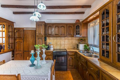 阿波罗尼亚Traditional House Milos的厨房配有木制橱柜和一张带花瓶的桌子。