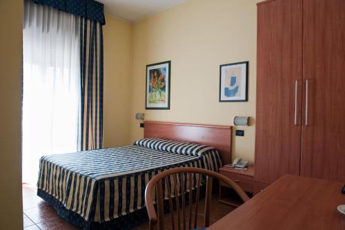 韦尔切利蓝带酒店的酒店客房配有一张床铺和一张桌子。