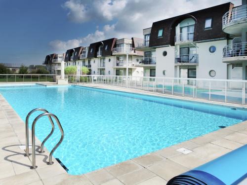 布列登Stylish Apartment in Bredene with Pool的一座大型游泳池,位于部分公寓大楼前