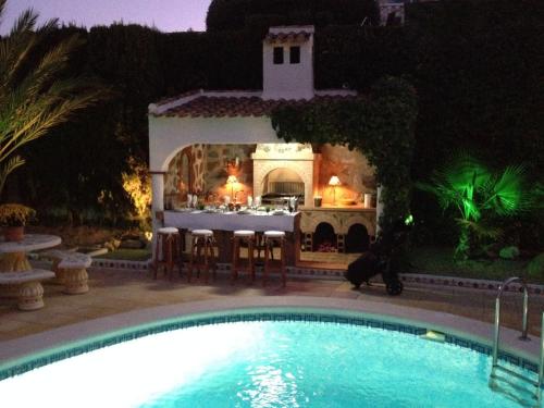罗哈莱斯Belvilla by OYO Villa Boya的夜间在房子前面的游泳池