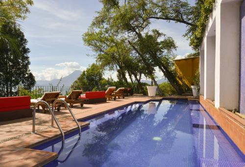 圣卡塔里纳帕洛波Hotel Casa Palopo的一座带桌椅的游泳池以及一座建筑