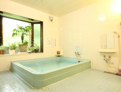 长野横仓日式旅馆的大型浴室设有大型蓝色浴缸。