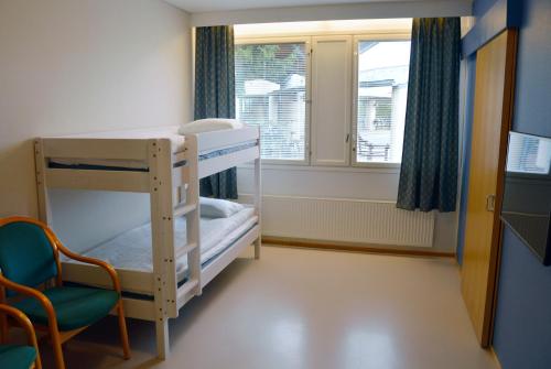 库奥皮奥Spa Hostel Kunnonpaikka的客房设有双层床、椅子和窗户。