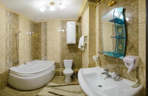 彼得罗巴甫洛夫斯克Ghostinitsa "Lina"的浴室配有盥洗盆、卫生间和浴缸。