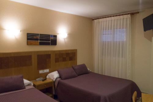 埃尔莫拉尔阿祖尔旅馆的酒店客房设有两张床和窗户。