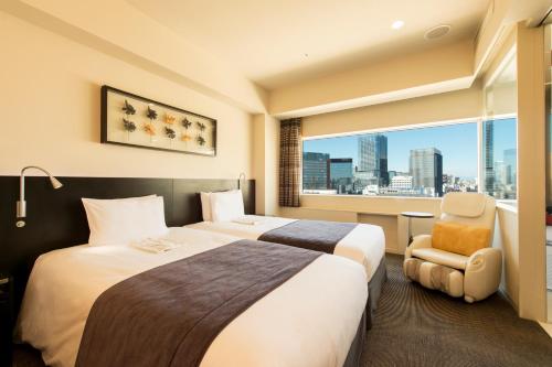 东京remm Akihabara的酒店客房设有两张床和窗户。