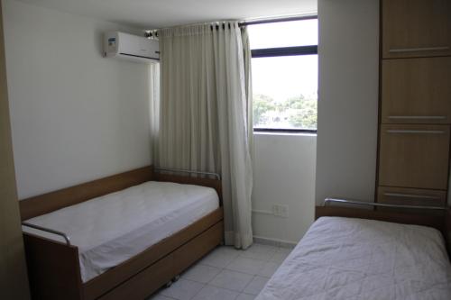 若昂佩索阿Portugal Flat的一间小卧室,配有两张床和窗户