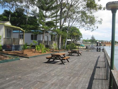 麦夸里港艾奇沃特假日公园酒店的水边木板路上的两张野餐桌