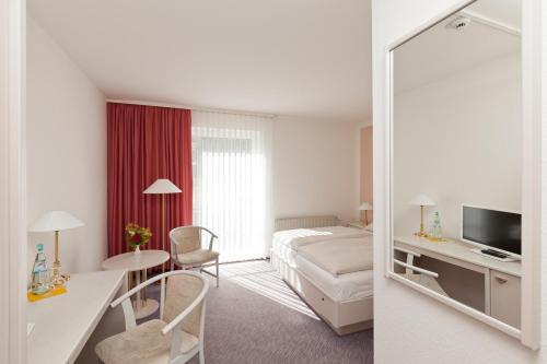 鲁特斯塔德·斯塔文哈瑞特瑞斯彻酒店的酒店客房,配有床和镜子