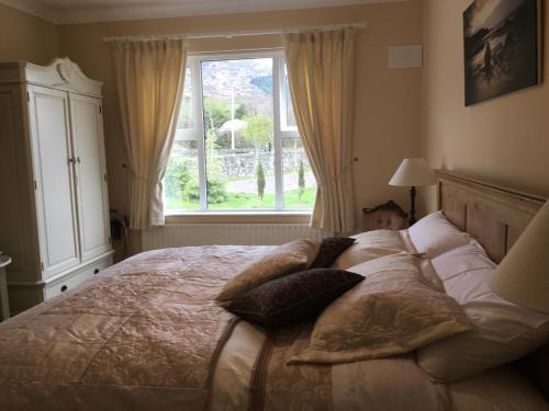 卡林福德格卢屋住宿加早餐酒店的卧室配有带枕头的床铺和窗户。