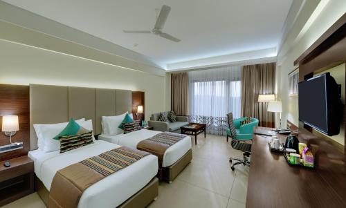 果阿旧城The Fern Kadamba Hotel And Spa的酒店客房设有两张床和一台平面电视。