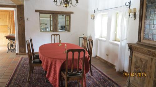 Schalkenbach麦森胡福度假屋的一间用餐室,配有红色的桌子和椅子