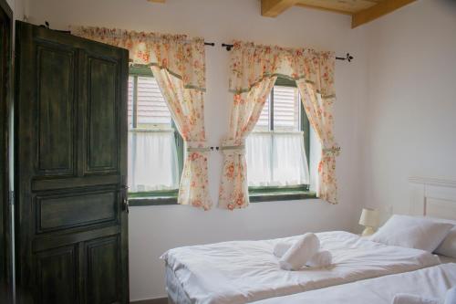采格莱德BÉNI family wine farm的一间卧室设有一张床和两个窗户。