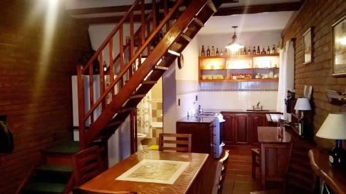 圣克莱门特雷图尤Cabañas El Maiten的厨房设有木桌和木楼梯。