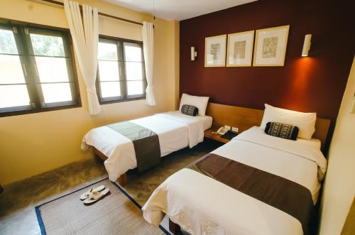 拜县拜县丽路酒店的酒店客房带两张床和两个窗户