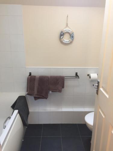 福里斯6 Varis Apartments的一间带卫生间和墙上时钟的浴室