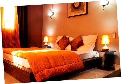 PoponguineLa Villa Serere的一间卧室配有两张床和两盏灯。
