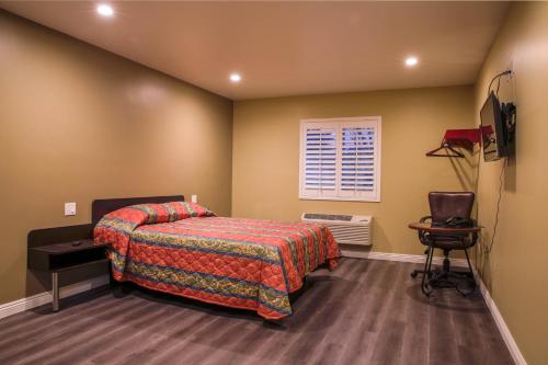 科斯塔梅萨纽波特湾酒店 的一间卧室配有一张床和一台电视