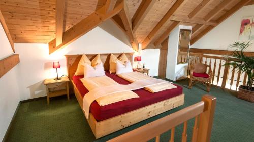 圣吉尔根沃尔夫冈湖莱特纳乡村酒店的一间带一张大床的卧室,位于一个拥有木制天花板的房间