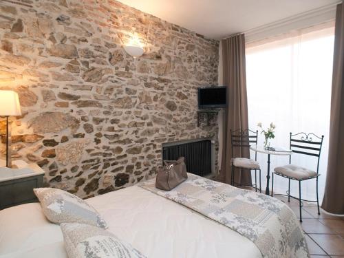 科利尤尔Hôtel la Bona Casa的一间卧室设有石墙和床