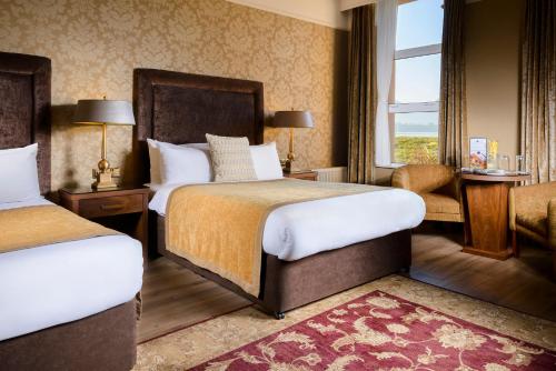 基拉尼湖畔酒店的酒店客房设有两张床和窗户。