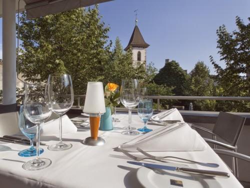 罗拉赫Hotel MARIOTTO am Burghof的阳台上的桌子上摆放着酒杯和餐巾