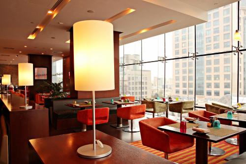 科威特ibis Kuwait Salmiya的餐厅设有桌椅和大窗户。