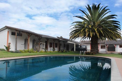 塔巴贝拉圣卡洛斯塔巴波拉酒店的棕榈树和游泳池的房子