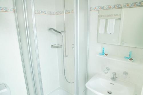 洛桑Résidence de l'Ours的带淋浴和盥洗盆的白色浴室