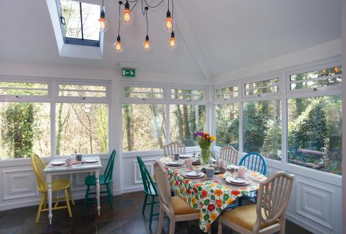 贝图瑟科伊德Summerhill Guest House的一间带桌椅和窗户的用餐室