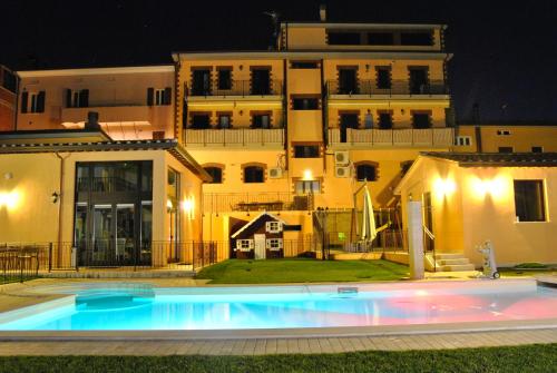 布鲁法Appartamenti Brufa Civico 13/17的一座游泳池,在晚上在建筑物前