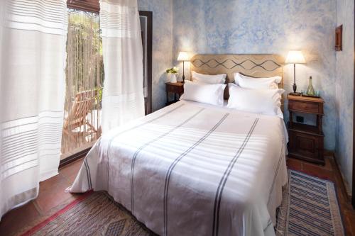 隆达阿拉维拉德洛斯巴诺斯酒店的一间卧室配有一张带白色床单的床和一扇窗户。