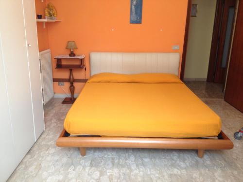 滨海库普拉Appartamento Via Adriatica Nord的橙色墙壁间的一张床位