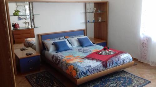 阿罗纳Appartamento Corallo的一间卧室配有一张带蓝色枕头的床