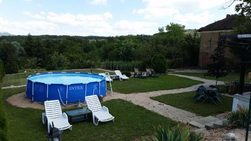 DŭbravkaGuest House Relax的一个带游泳池、椅子和桌子的庭院