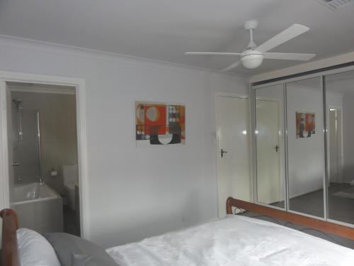 阿德莱德优越位置宽敞度假屋的一间卧室配有一张床和吊扇