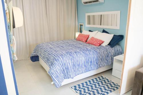 皮帕Apartamento Solar Água 107的一间卧室配有一张带红色枕头的床