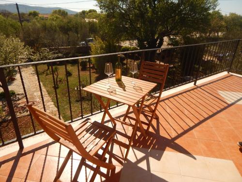 GorišMandić Rooms的阳台上配有一张木桌和两把椅子