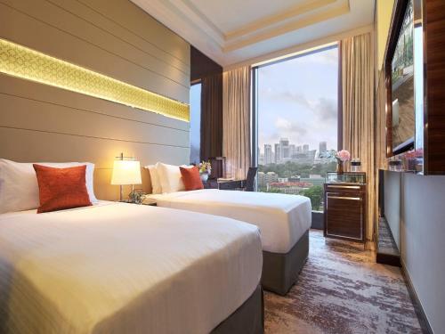 新加坡Holiday Inn Singapore Little India, an IHG Hotel的酒店客房设有两张床和大窗户。