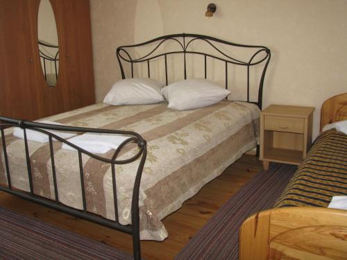 KadarėsPiligrimo Užeiga的一间卧室配有一张带黑色框架和白色枕头的床。
